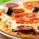 pizza croccante con salamino piccante, olive nere e pomodori freschi