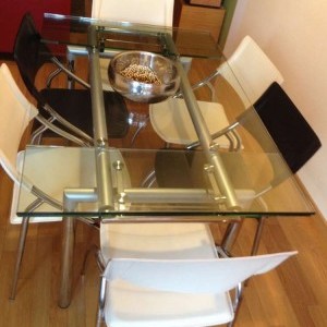 tavolo in cristallo e acciaio con sei sedie